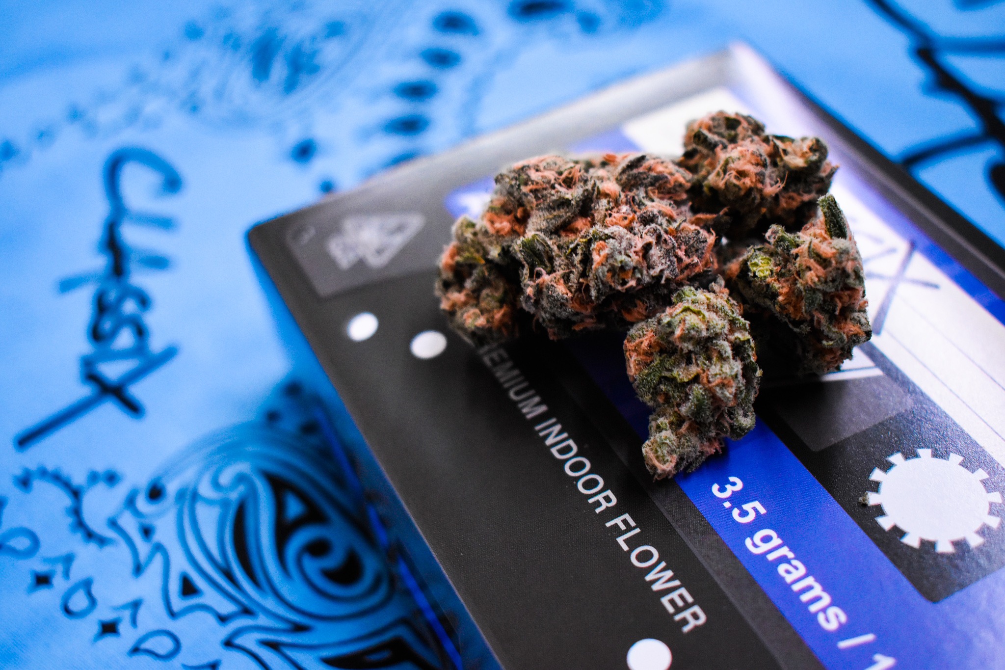 Blue Dream cannabis flower photographed on blue cassette-inspired Classix packaging with a patterned textile.