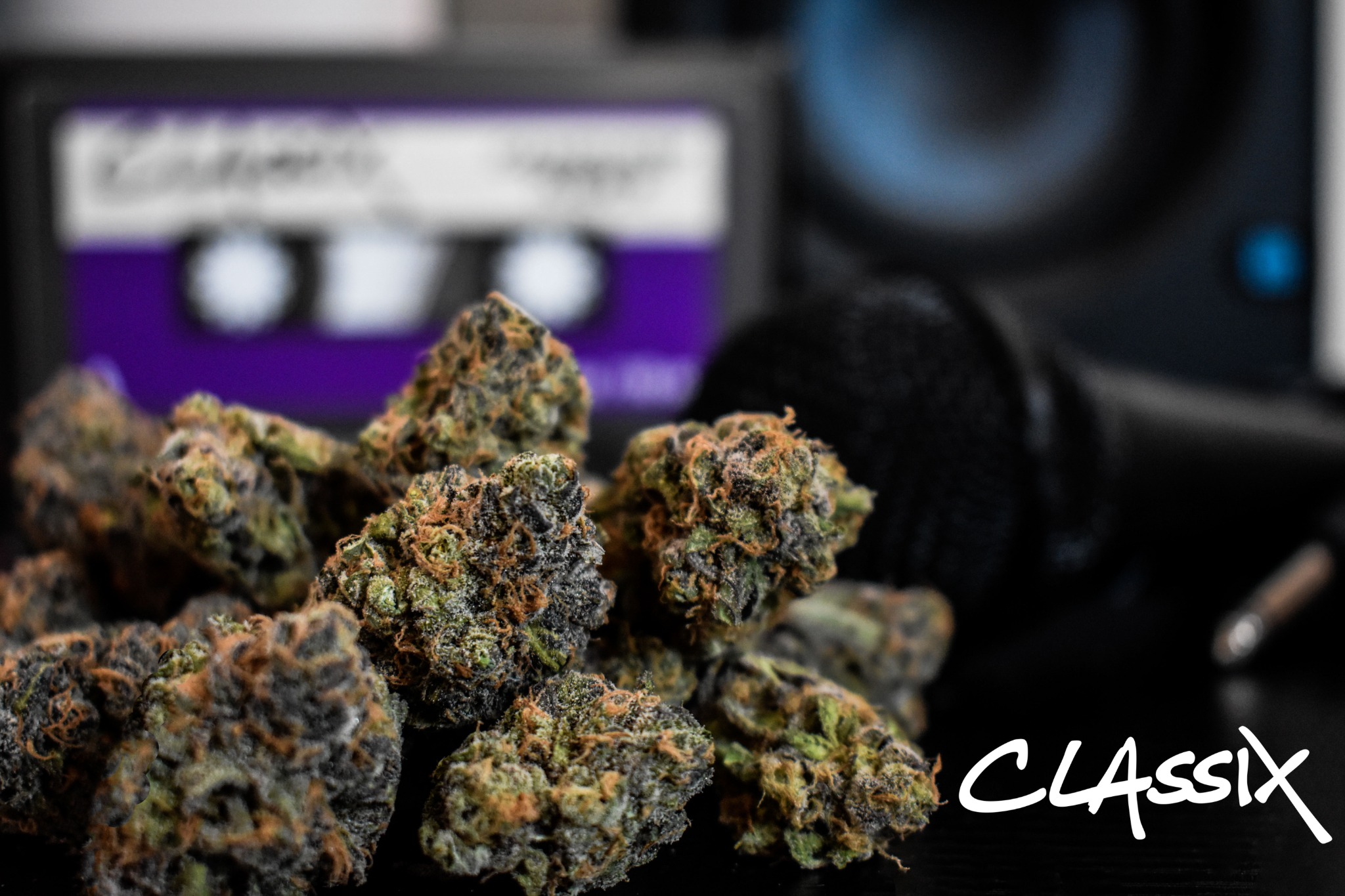Granddaddy Purple cannabis flower photographed with purple cassette-inspired Classix packaging and audio equipment.