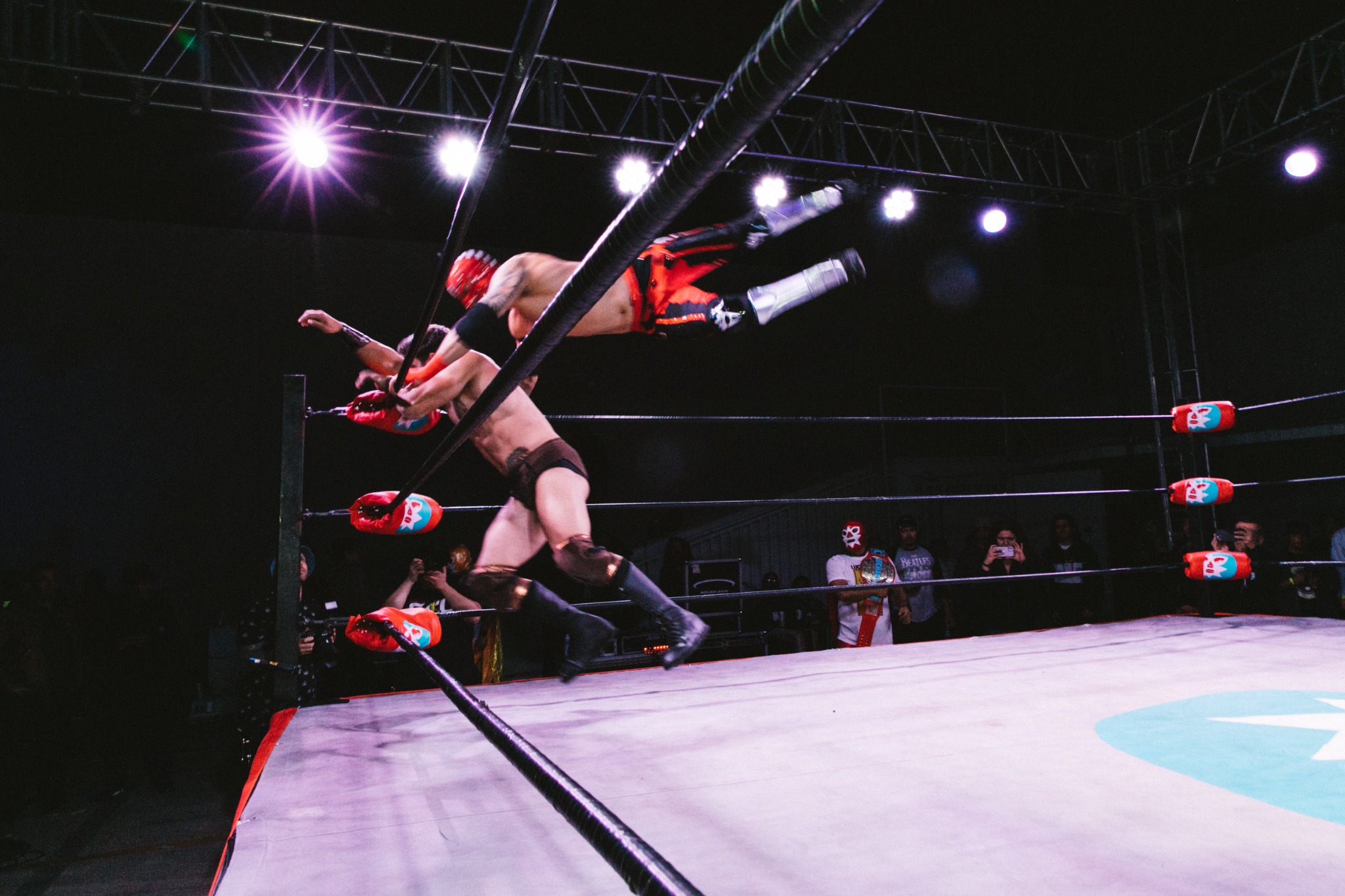 Wrestlers in motion under the Mota Mania lights. Photo: Hazy.
