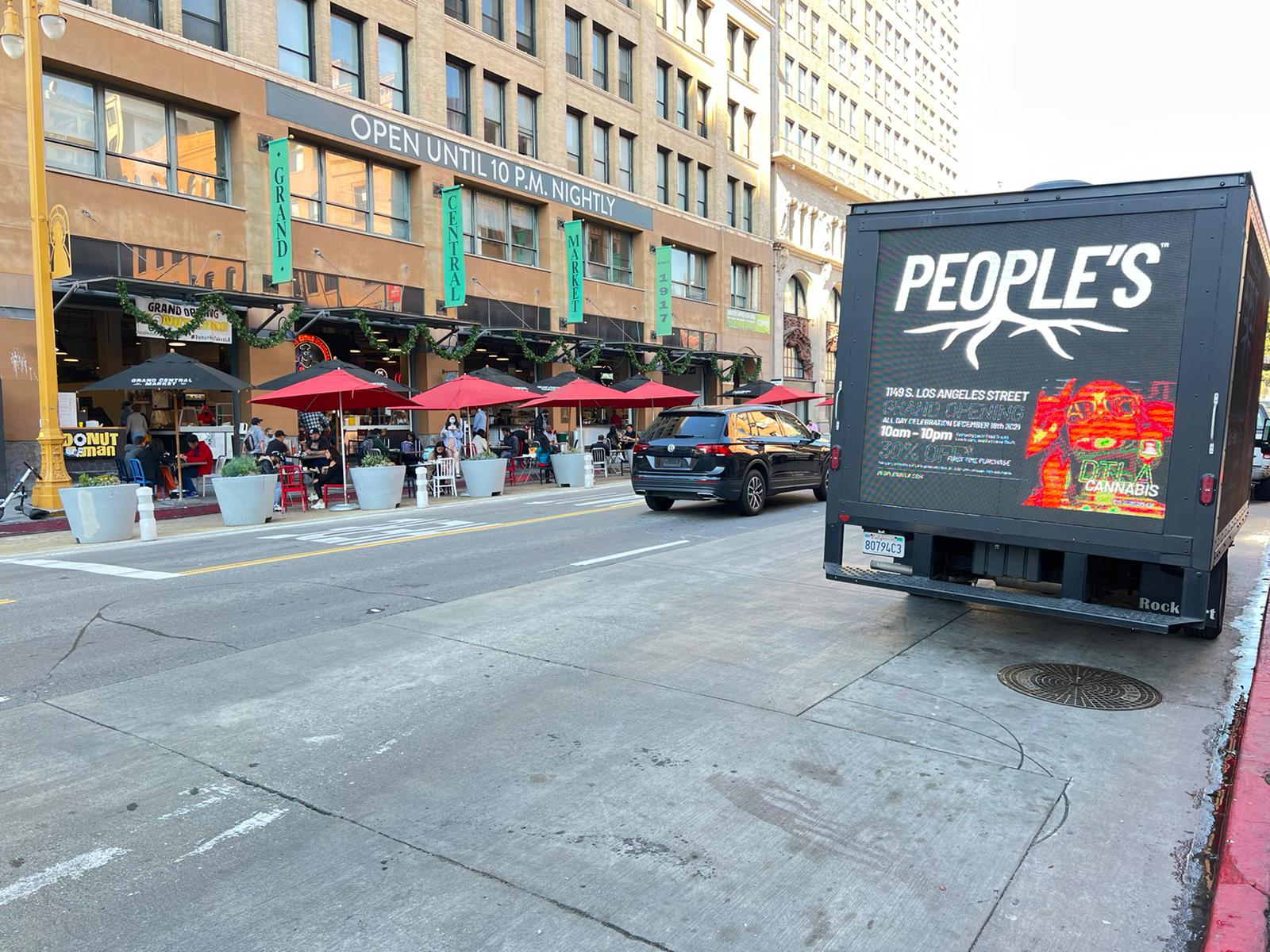People’s digital advertising truck parked near Grand Central Market with launch creative visible across its screens.